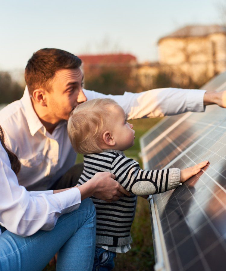 A father and child looking at a solar panel